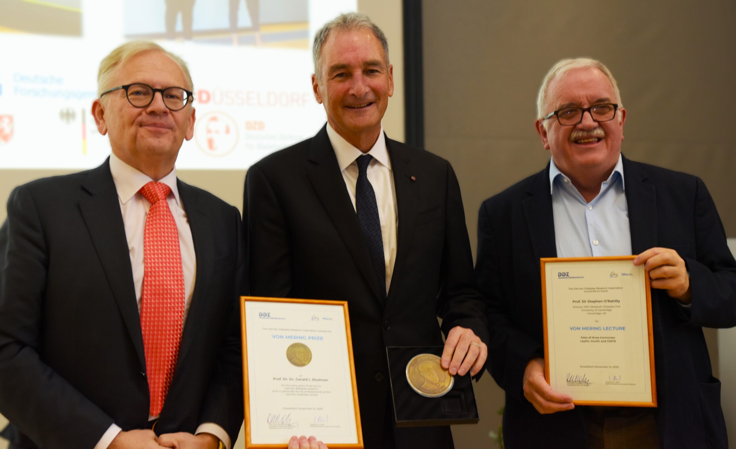Drei Männer, mit Medaille