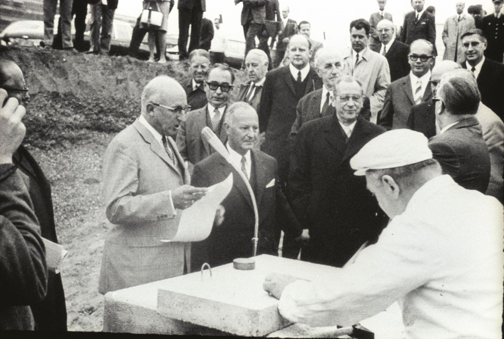 Ein Mann hält vor mehreren Männern eine Rede zur Grundsteinlegung des DDZ-Gebäudes 1969
